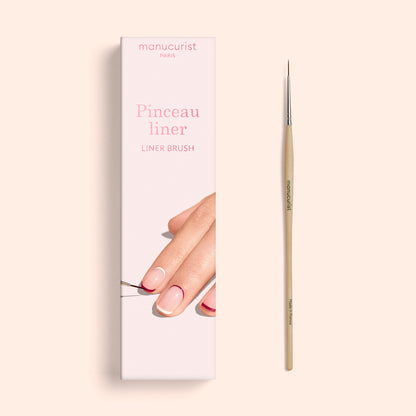 Une boîte intitulée « Liner Brush » de Manucurist, présentant une image d’ongles manucurés et d’un pinceau fin de Nail Art appliquant du vernis, exposée à côté du véritable pinceau liner à pointe fine fabriqué avec des poils synthétiques véganes de qualité professionnelle.