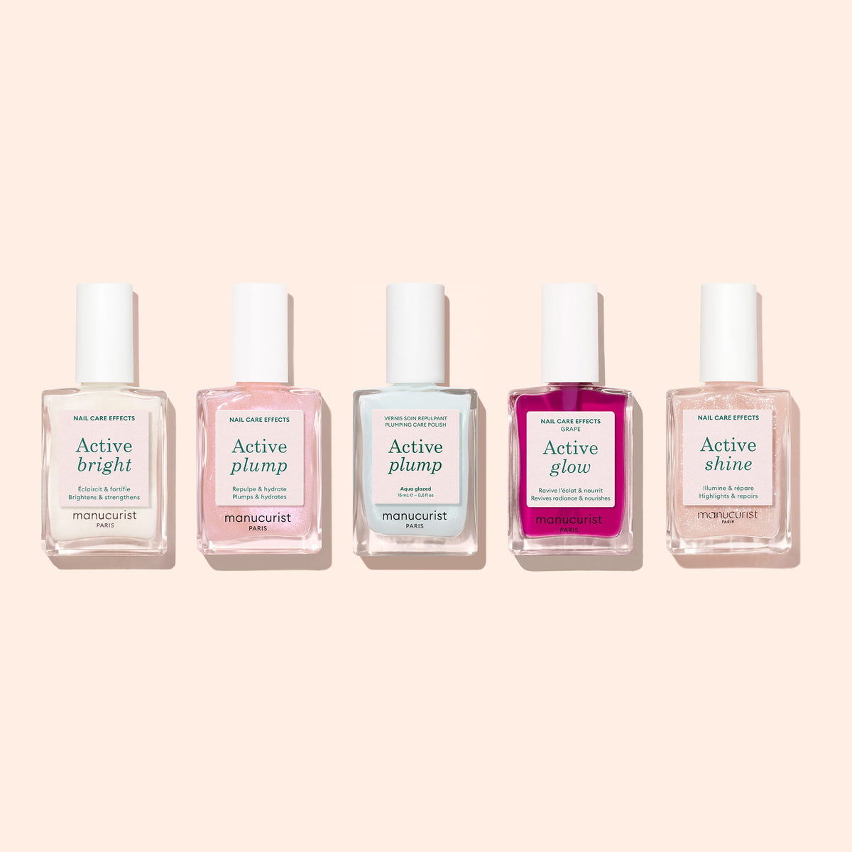 Five bottles of Manucurist nail care treatments are lined up against a light background, each labeled with different effects: Active Bright, Active Plump (twice), Active Glow, and Active Shine. The collection features volumizing nail care formulas like the Manucurist Active™ Plump Aqua Glazed, designed to deliver hydrated nails and visibly enhance their natural beauty.