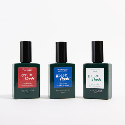Trois flacons du trio de vernis à ongles Red, White Blue de Manucurist sont alignés sur un fond blanc, chacun présentant des teintes rouge, blanche et bleue éclatantes.