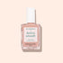 Un flacon de vernis soin Manucurist Active™ Smooth 01 avec un bouchon blanc est présenté sur un fond pêche pâle, mettant en valeur ce soin CC Polish d’origine végétale formulé pour perfectionner et protéger vos ongles.