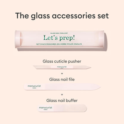 Une image du trio d’accessoires pour ongles en verre Manucurist-us, comprenant un étui cylindrique portant l’inscription "Lets prep!", un polissoir à ongles en verre, un repousse-cuticules et une lime à ongles, le tout soigneusement disposé sur un fond clair.