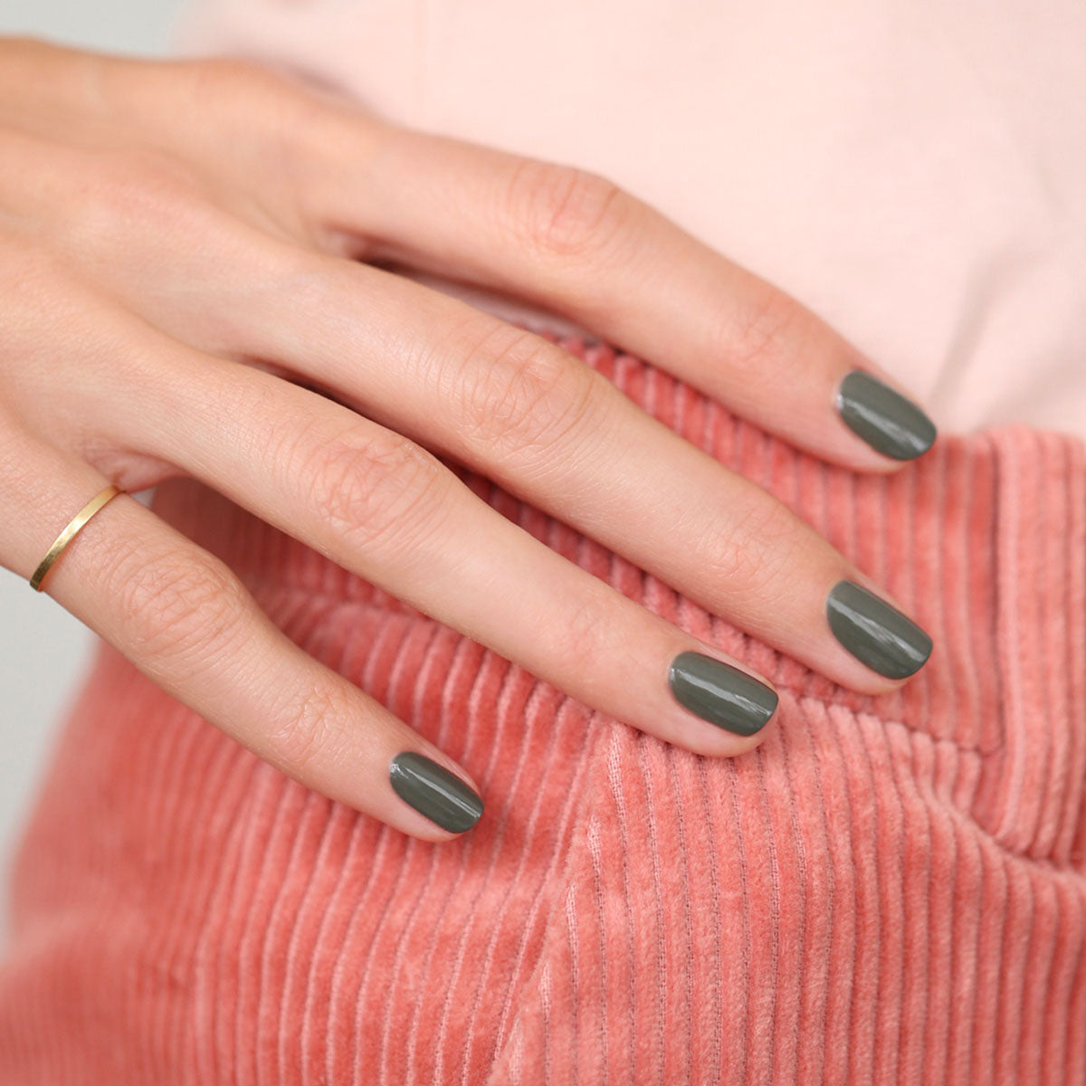 A hand with short, neatly manicured nails painted in Manucurist&