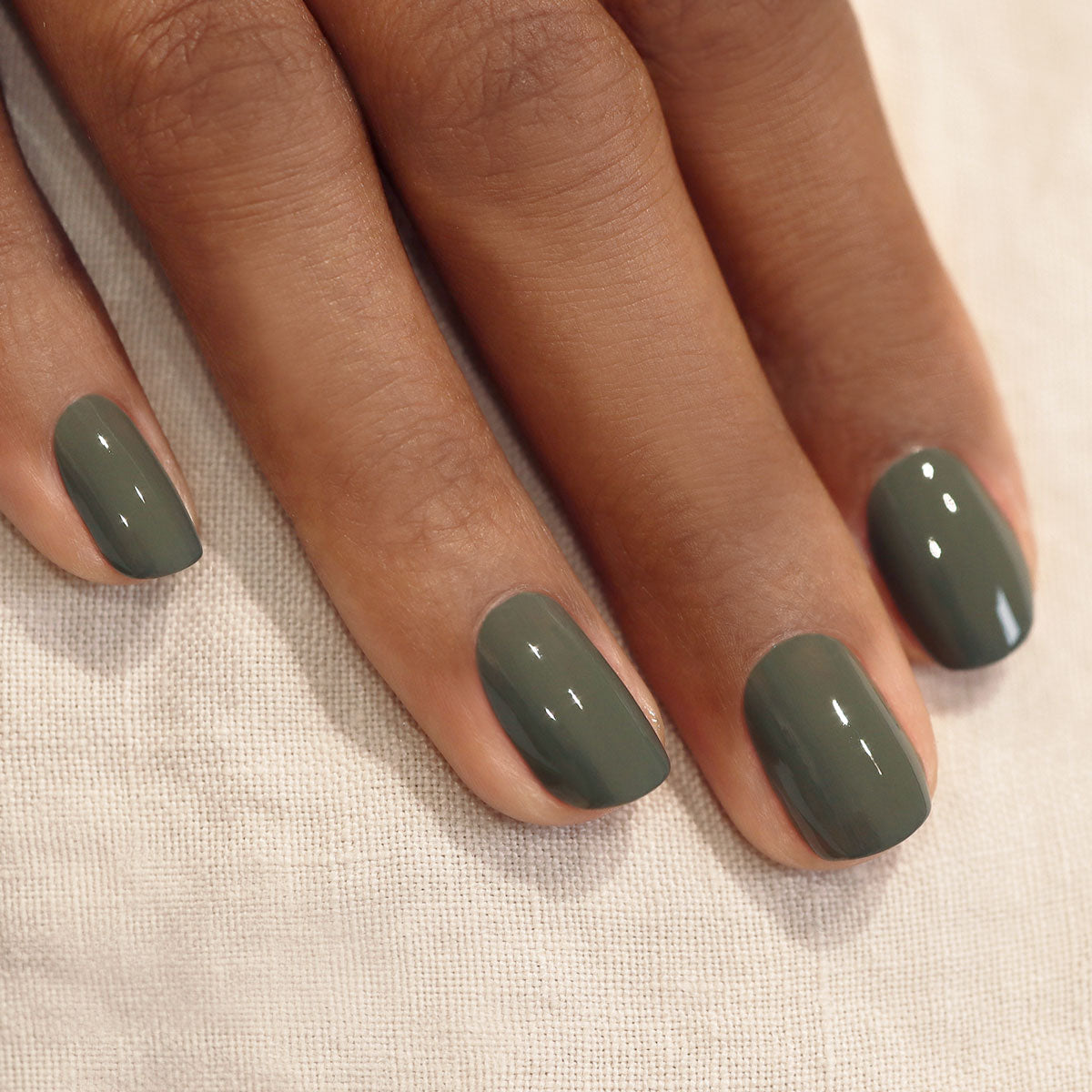 A hand with short, neatly manicured nails painted in Manucurist&
