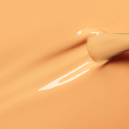A close-up of a Manucurist Abricot brush spreading creamy pastel orange nail polish, creating smooth, glossy streaks on a matching background.