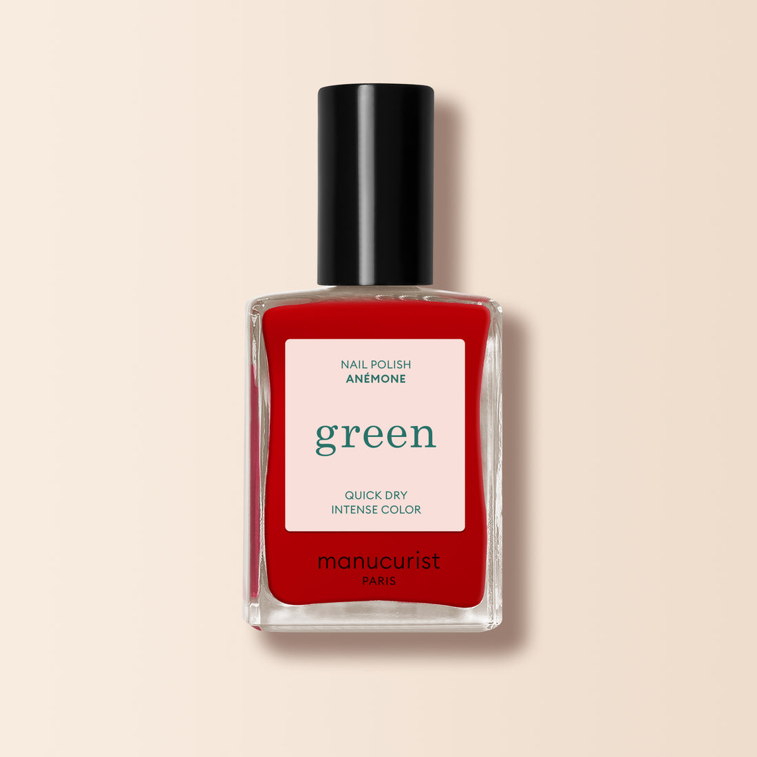 Un flacon de vernis à ongles Anémone de Manucurist de la gamme Green™, dans une teinte rouge vibrante, présenté dans un flacon rectangulaire en verre transparent avec un bouchon noir et une étiquette blanche affichant les détails du produit.
