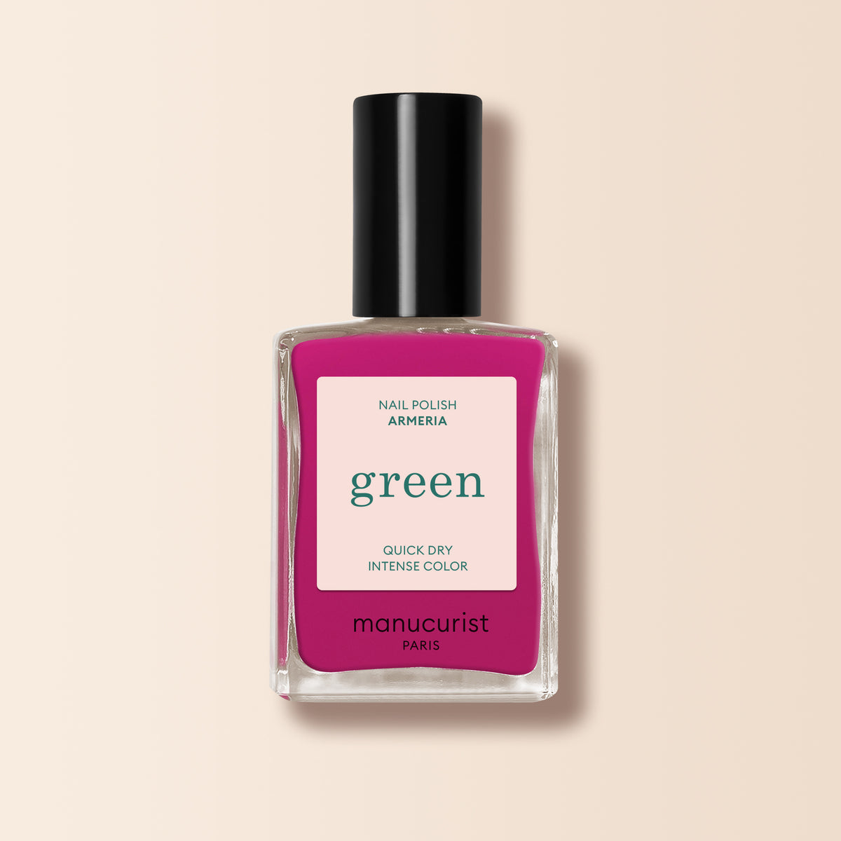 A bottle of Manucurist Armeria nail polish, a bright pinky mauve from the Green™ range, featuring intense color and quick-dry formula with a black cap, is shown against a beige background.