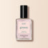 A bottle of Manucurist nail polish in the shade “Blossom,” featuring a creamy light pink color, black cap, and square transparent glass bottle from the Green range is displayed against a beige background.