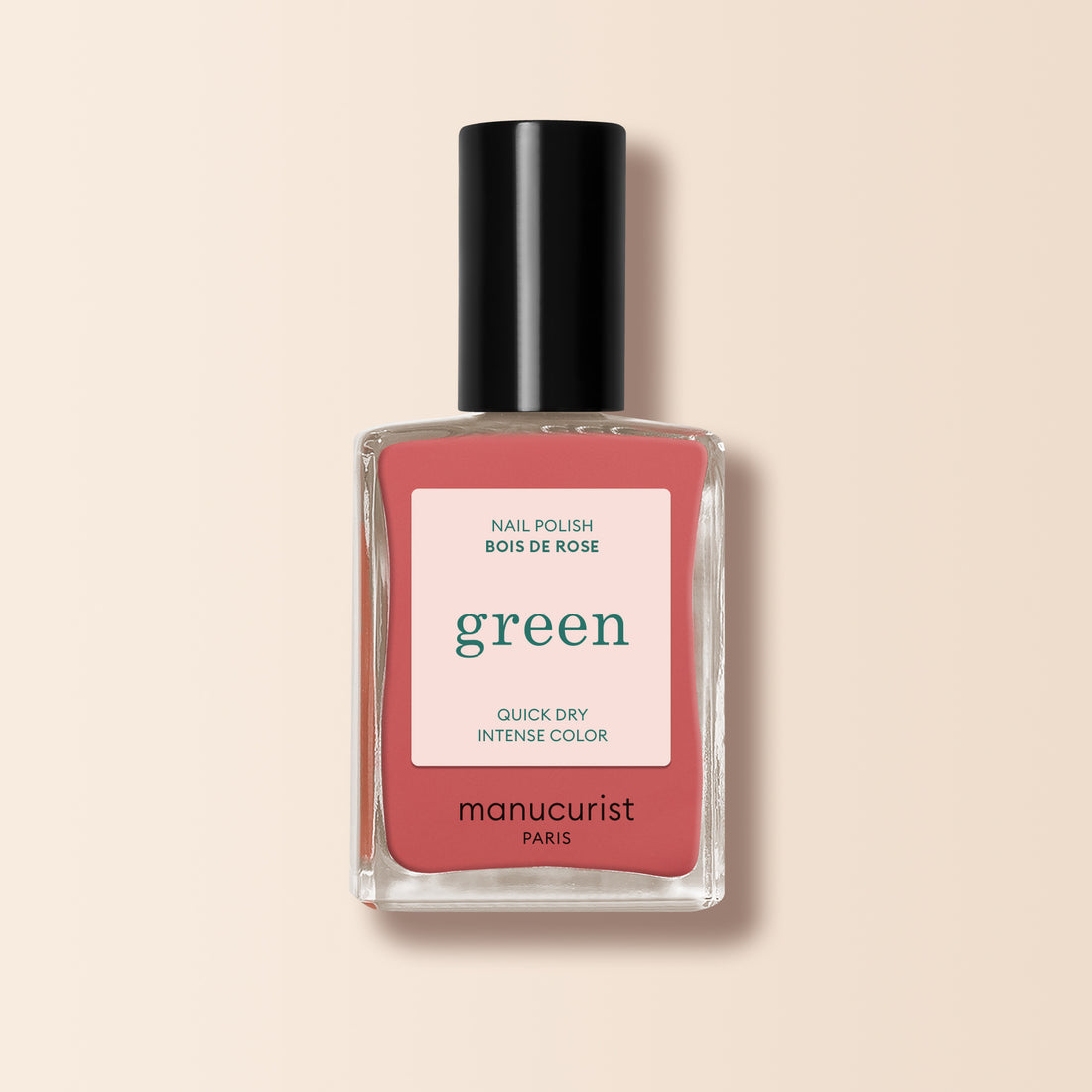 Le vernis à ongles Bois de Rose de Manucurist présente une teinte rose poudré avec une étiquette "green" rose, offrant une couleur intense à séchage rapide sur un fond beige clair.