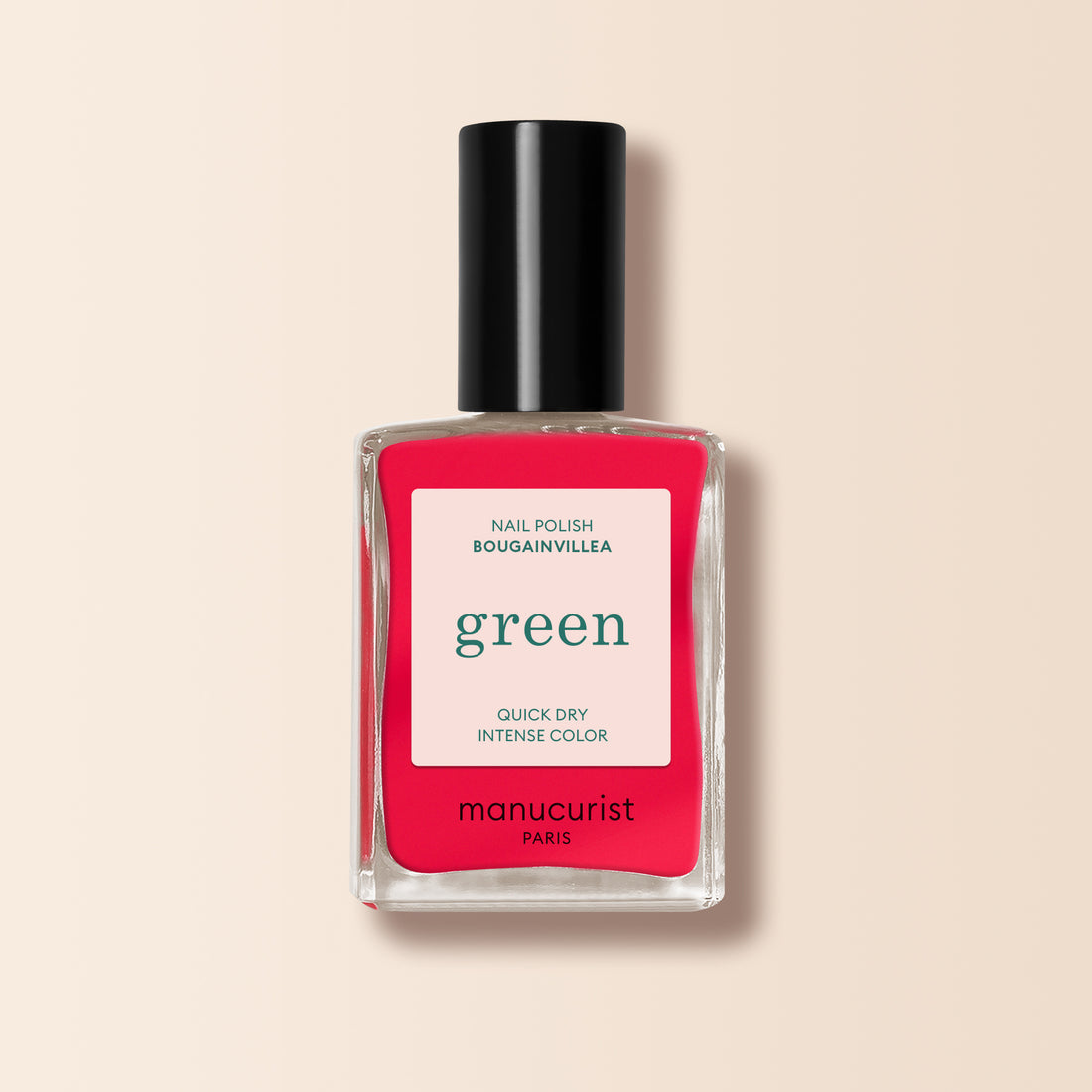 Un flacon de Manucurist Bougainvillea — un vernis à ongles rose rouge vif avec un bouchon noir et une étiquette blanche indiquant "green, séchage rapide, couleur intense et vernis à ongles.
