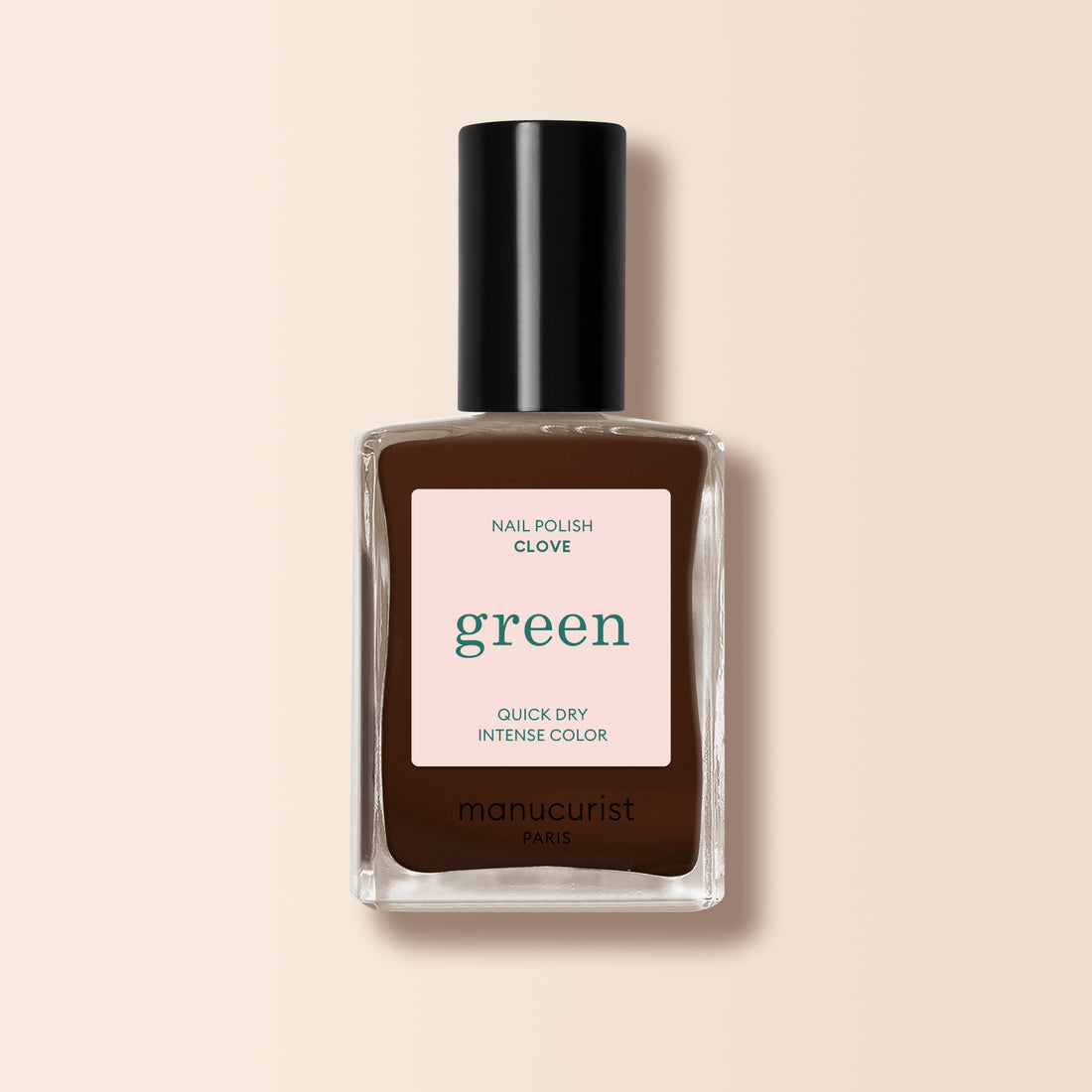 Un flacon de vernis à ongles Clove de Manucurist, une teinte brun chocolat de la gamme Green™, avec un bouchon noir et une étiquette indiquant "green, séchage rapide, couleur intense", sur un fond beige clair.