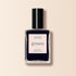 Un flacon carré en verre de vernis à ongles Manucurist Dark Night, teinte bleu nuit avec un bouchon noir. L’étiquette indique Dark Night, gamme Green™, Quick Dry Intense Color, sur fond pâle.