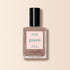 A bottle of Manucurist nail polish in the shade Dove Beige, shown in a clear rectangular bottle with a black cap and pastel beige label, set against a light beige background.