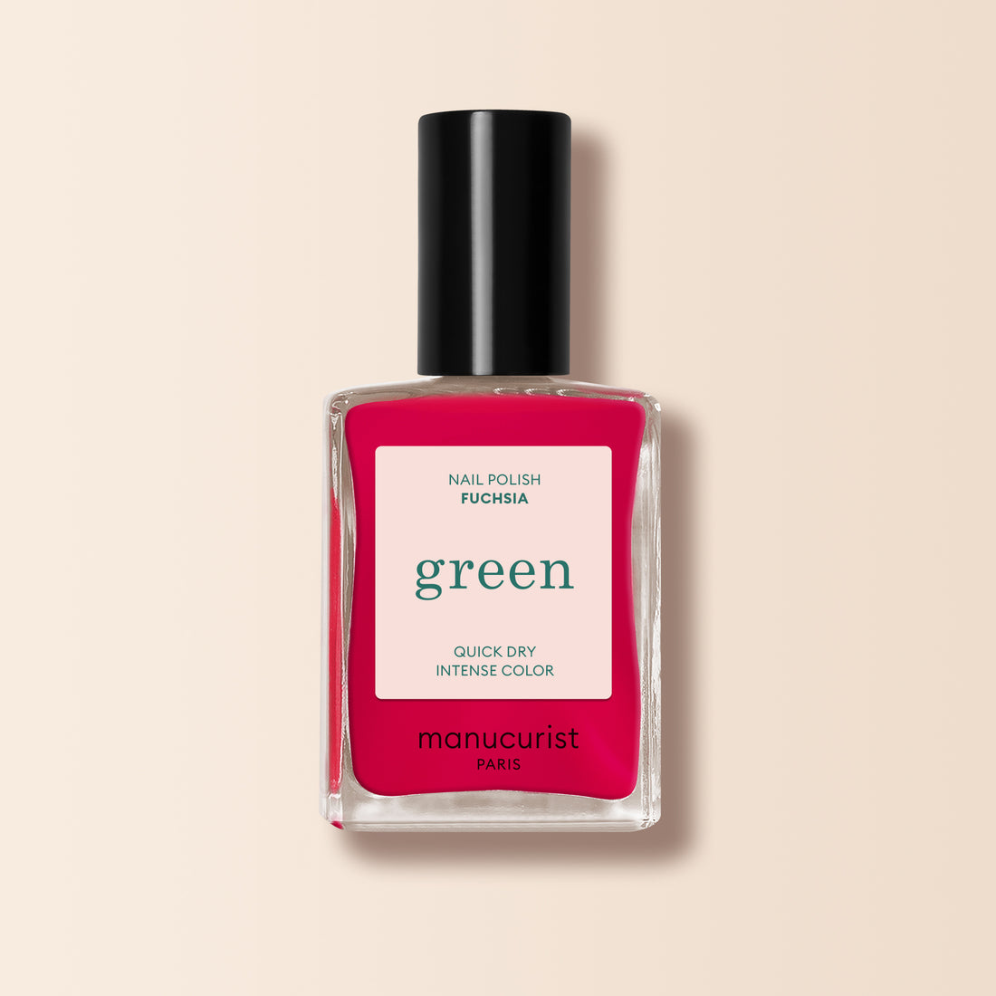 Un flacon de vernis à ongles Manucurist Fuchsia avec bouchon noir et une teinte rose violacé vibrante, issu de la gamme Green™, présenté sur fond beige clair.