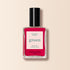 A bottle of Manucurist Fuchsia nail polish, featuring a black cap and vibrant pinky purple shade, from the Green™ range, shown on a light beige background.