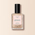 Un flacon de vernis à ongles Manucurist Gold de la gamme Green, avec un bouchon noir et une étiquette rose indiquant "green," "nail polish gold," et "quick dry intense color," présenté sur un fond beige.