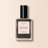 A bottle of Manucurist Khaki nail polish with a black cap, featuring quick-dry and intense color, sits on a light beige background—ideal for a modern manicure with its subtle grey undertone.