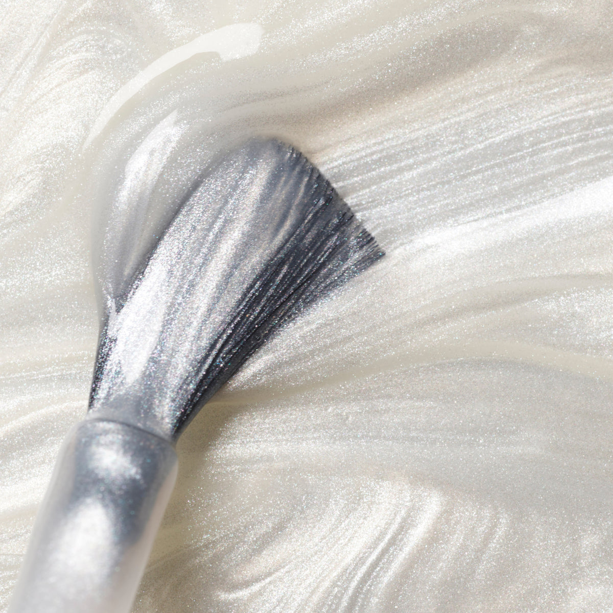 A close-up of a makeup brush spreading Manucurist&