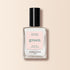 Un flacon en verre transparent de vernis à ongles Milky White de Manucurist, avec un bouchon noir, se tient debout sur un fond beige pâle.