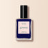 Un flacon de vernis à ongles Navy Blue de Manucurist de la gamme Green™, avec un bouchon noir. L’étiquette indique Nail Polish Navy Blue, Quick Dry Intense Color et manucurist Paris. Le fond est beige doux.