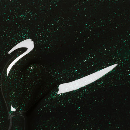 Close-up of Manucurist’s Poison, a forest green nail polish with fine glitter, featuring a glossy shimmer and visible brush strokes.