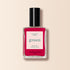 A bottle of Manucurist Péonie nail polish in a bright pink shade, featuring a black cap and a "green, quick dry intense color" label, is displayed against a cream background.