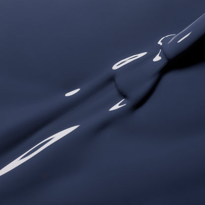 Close-up of a smooth, bluish grey liquid surface with gentle ripples and reflections, evoking abstract shapes and fluid motion in elegant shades reminiscent of Poppy Seed by Manucurist.