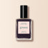 A Manucurist Queen of Night nail polish bottle, featuring a deep purple shade and black cap, is displayed against a light beige background.