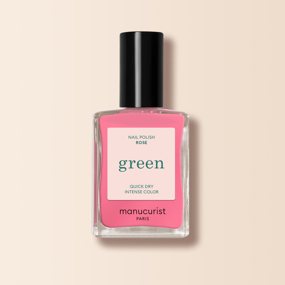 Un flacon de vernis à ongles Manucurist Rose rectangulaire en verre transparent, avec bouchon noir et étiquette rose, présenté sur un fond beige clair.