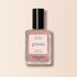 A bottle of Manucurist Shell Beige nail polish from the Green™ range, with a black cap, clear glass bottle, and a beige-pink label reading “green, quick dry intense color,” set against a light beige background.