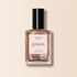 A bottle of Manucurist Bronzé nail polish in a bronze-copper shade with a black cap, set on a light beige background. The label highlights Quick Dry Intense Color.