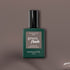 Un flacon de vernis gel Green Flash Clay de Manucurist est centré sur un fond taupe, mettant en valeur le flacon vert foncé avec son bouchon noir et son texte blanc qui souligne cette teinte taupe innovante.
