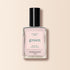 A bottle of Manucurist Gloss nail polish with a black cap and pink label reading "green, quick dry intense color." The iridescent light pink polish inside features subtle shimmer, shown against a beige background.