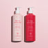 The Rose Botanical Cream  Artisan Soap Duo - Cosmos Organic by Manucurist features two pink pump bottles for hand and body care, delicately rose-scented, displayed on a light pink background.