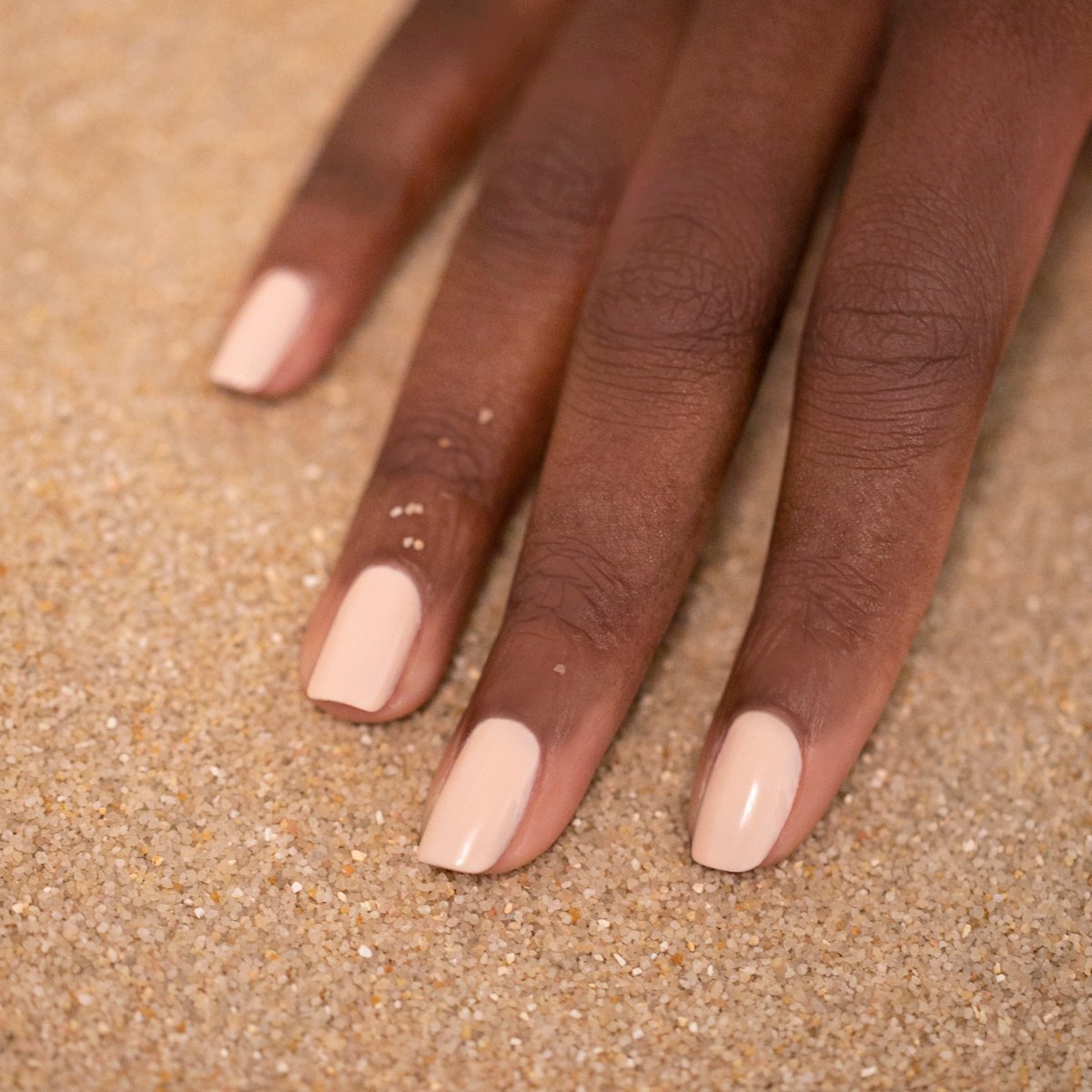 A hand with neatly manicured nails painted in Manucurist&