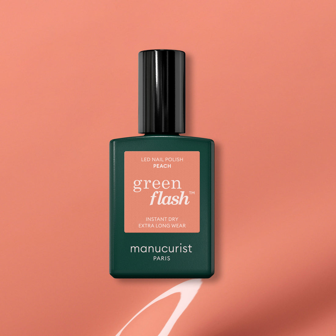 Un flacon de vernis gel Manucurist Green Flash en teinte Peach repose sur un fond pêche avec un trait blanc peint en dessous. L&
