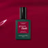 A bottle of Manucurist Violeta gel polish rests on a glossy magenta surface, light reflecting off the background to highlight its vibrant pink-purple tones.